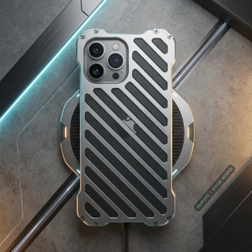 Shockproof dark gray aluminum iPhone metal case with hollow diagonal ventilation slots for heat dissipation, rugged screw-accented corners, placed on a futuristic charging platform